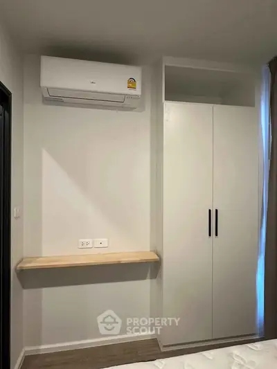 Modern bedroom with built-in wardrobe and air conditioning unit, perfect for comfortable living.