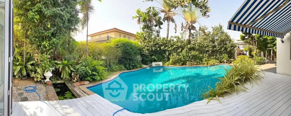 Stunning backyard pool with lush greenery and modern deck, perfect for relaxation.