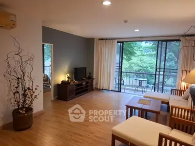 Spacious living room with wooden flooring and balcony view