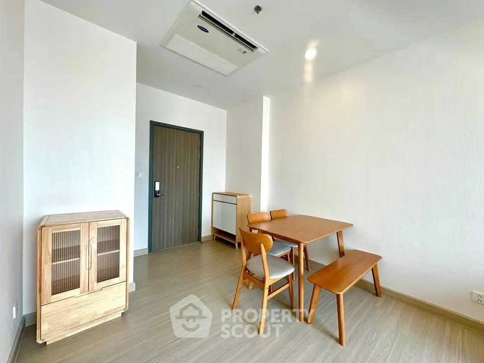Minimalist dining area with wooden furniture and modern design in a bright apartment.