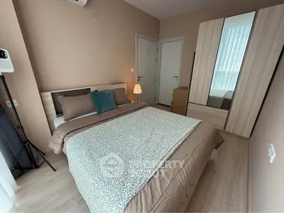 Cozy bedroom with modern decor and ample natural light, featuring a stylish wardrobe and comfortable bedding.