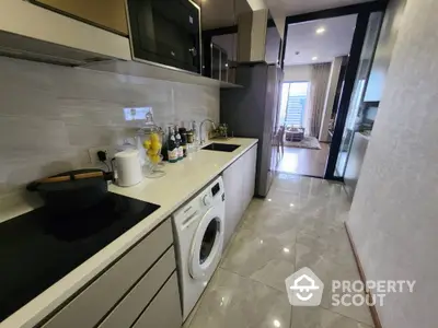 Modern kitchen with sleek appliances and washing machine in stylish apartment