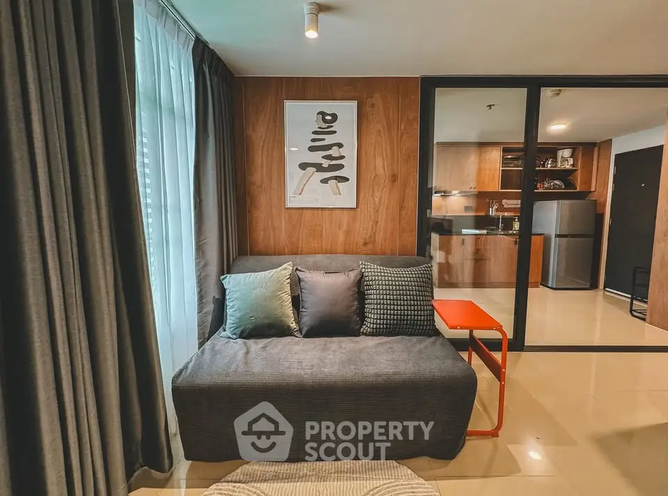 Modern living room with stylish decor and open kitchen layout.