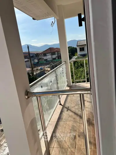 Charming balcony with scenic view of neighborhood and mountains, perfect for relaxation.