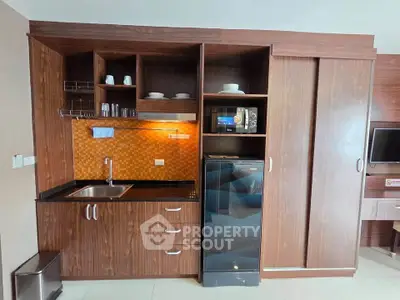 Modern kitchen with sleek wooden cabinets and built-in appliances in a stylish apartment.