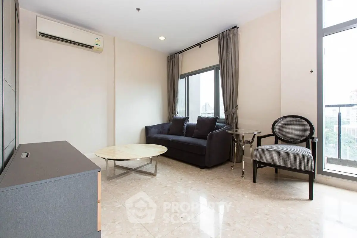 Modern living room with sleek furniture and large windows offering city views.