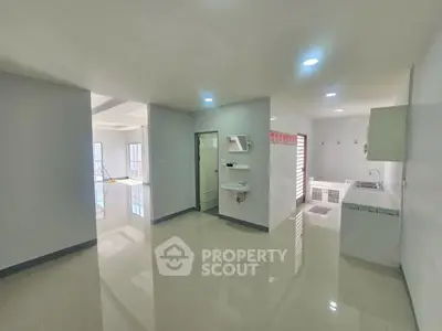 Spacious open-plan living area with modern kitchen and glossy floors