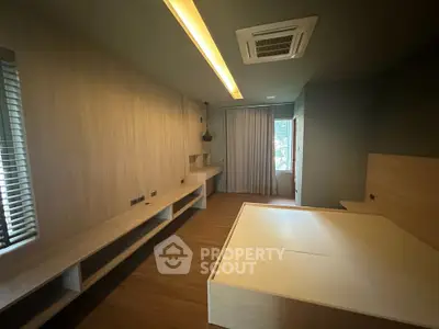 Spacious modern bedroom with built-in furniture and large window