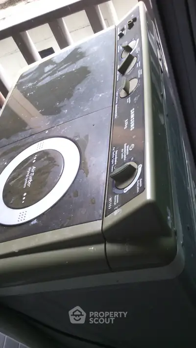 Compact washing machine on a balcony, ideal for urban apartments.