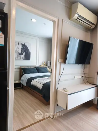 Modern bedroom with wall-mounted TV and air conditioning in stylish apartment.