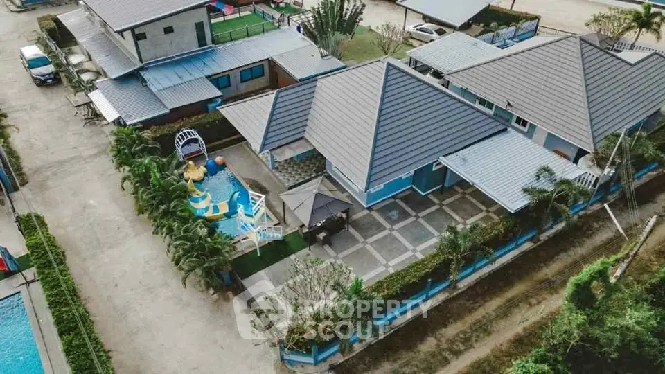 Aerial view of a modern residential property with a spacious yard and pool, showcasing contemporary architecture.