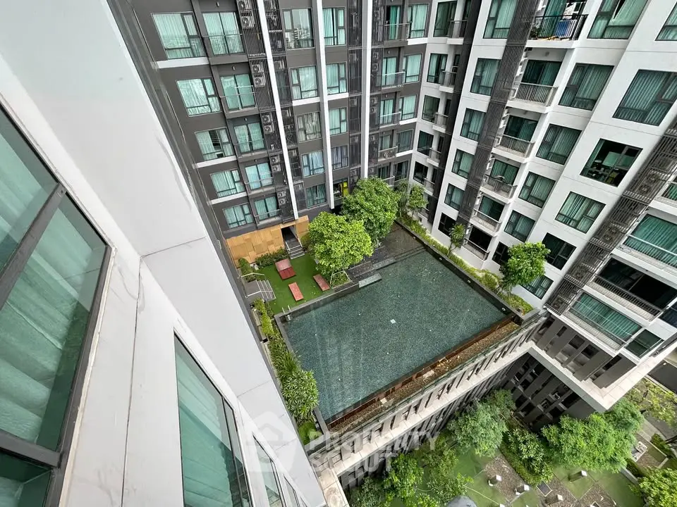 Modern apartment complex with central pool and lush greenery, offering a serene urban living experience.
