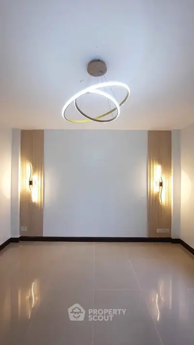 Modern minimalist room with stylish lighting and sleek tile flooring, perfect for contemporary living.