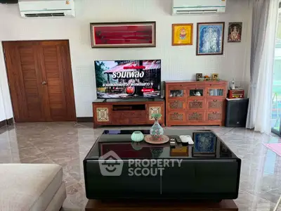 Spacious living room with modern decor and large TV, perfect for entertainment and relaxation.