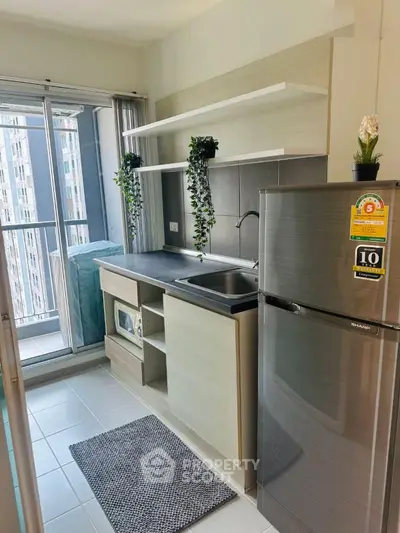 Modern kitchen with sleek appliances and balcony view in a stylish apartment.