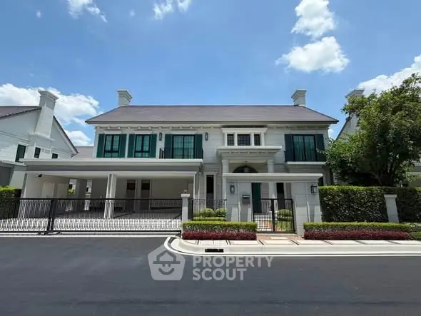 Elegant two-story house with manicured garden and spacious driveway in a serene neighborhood.