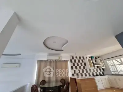 Modern open-plan kitchen and dining area with unique ceiling design