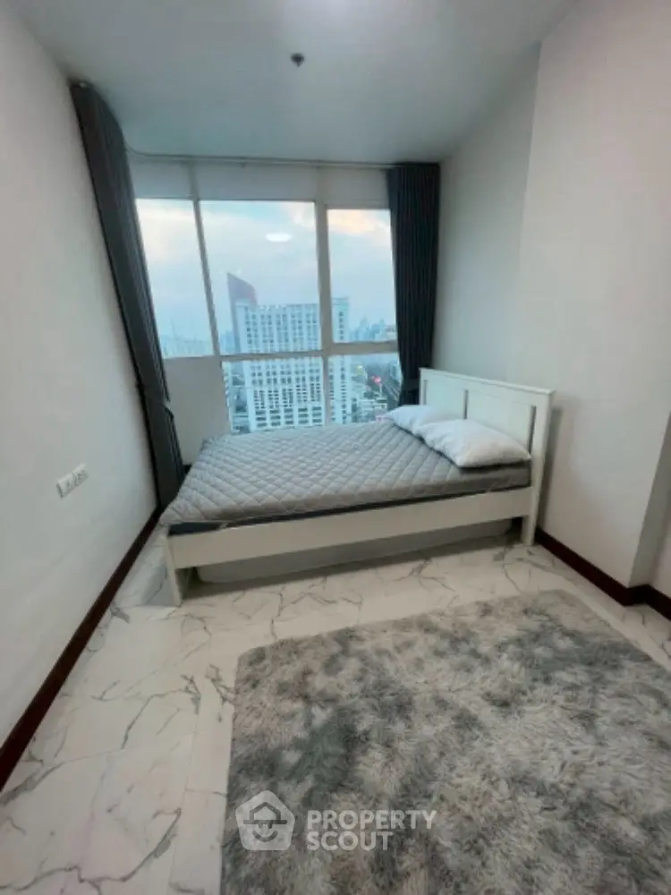 Modern bedroom with city view, featuring a cozy bed and stylish decor.