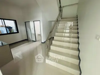 Modern staircase in sleek interior with glossy tiled flooring