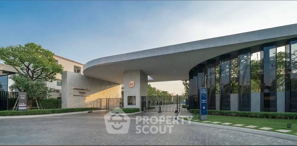 Modern luxury residential entrance with sleek architecture and lush greenery