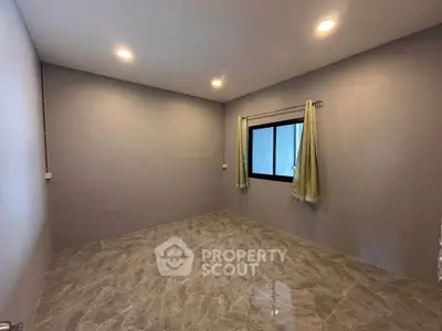 Spacious empty room with modern lighting and tiled flooring