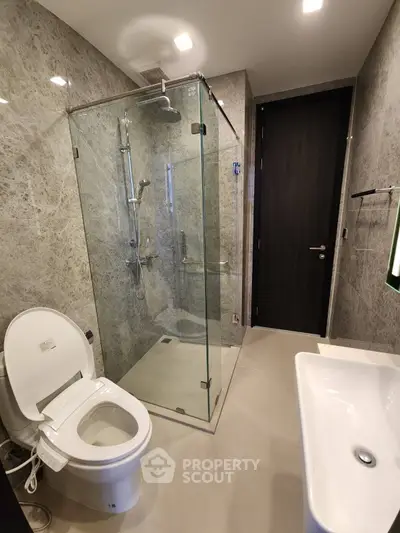 Modern bathroom with glass shower and sleek fixtures in luxury apartment