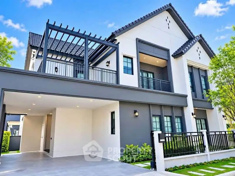 Modern two-story house with sleek design and spacious balcony, featuring a stylish pergola and lush greenery.