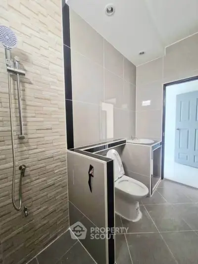 Modern bathroom with sleek tiles and contemporary fixtures in a stylish home.