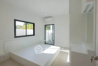 Bright minimalist bedroom with large window and air conditioning, featuring a modern design and ample natural light.