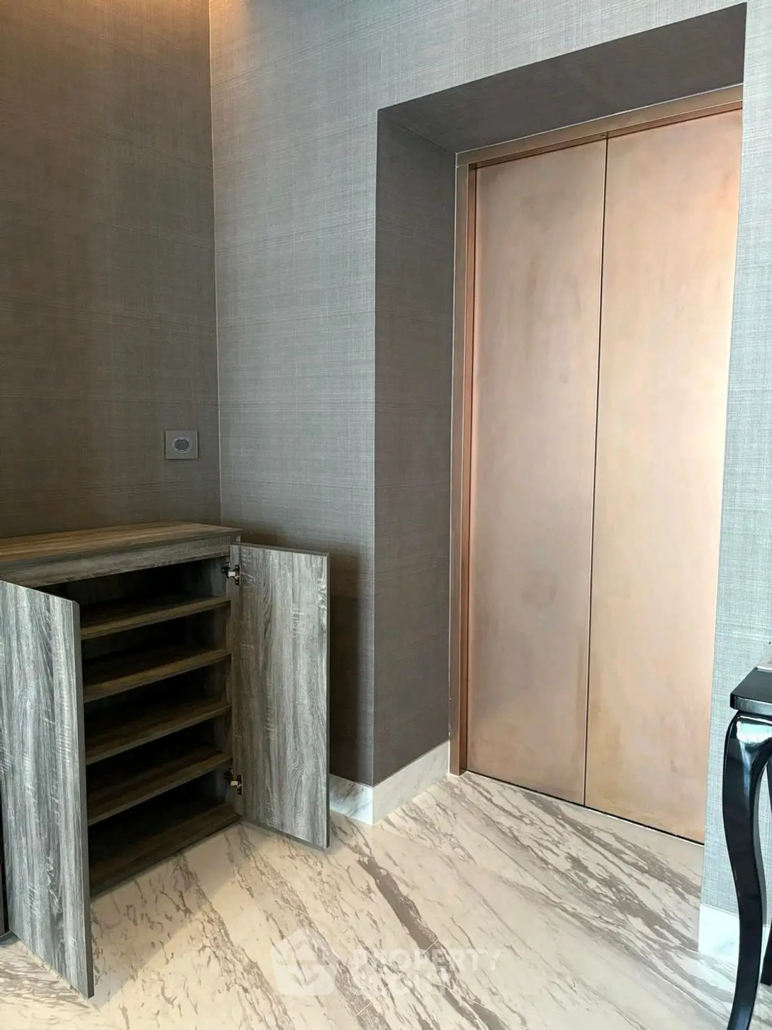 Elegant elevator lobby with marble flooring and modern shoe cabinet