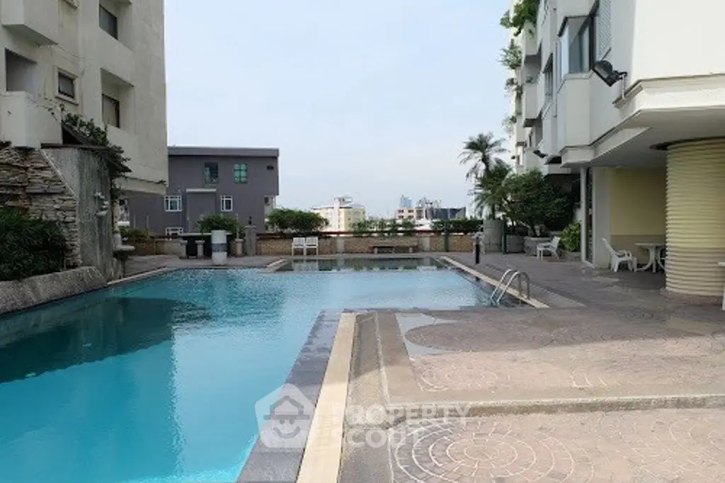 Luxurious apartment complex with a serene outdoor pool and city views.