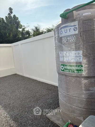 Outdoor water storage tank in a residential backyard with privacy fence