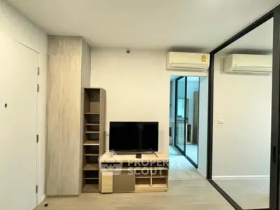 Modern living room with sleek TV stand and mirrored wardrobe in stylish apartment.