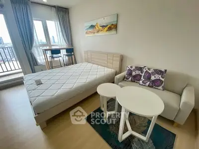 Modern bedroom with balcony view, featuring cozy bed and stylish seating area.