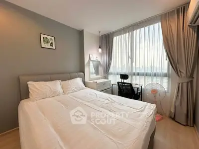 Modern bedroom with large window and stylish decor in a high-rise apartment.