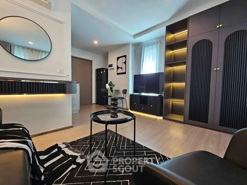 Modern living room with stylish decor, black furniture, and ambient lighting.