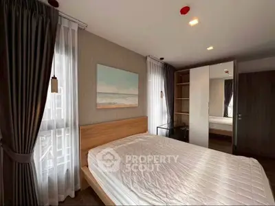 Modern bedroom with stylish decor and ample natural light in a contemporary apartment.