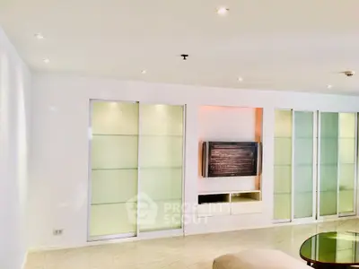 Modern living room with sleek built-in TV unit and sliding glass doors.