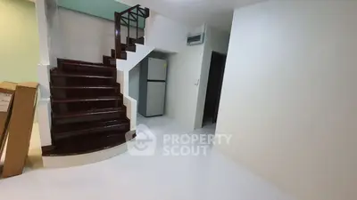 Modern interior with sleek staircase and compact kitchen area