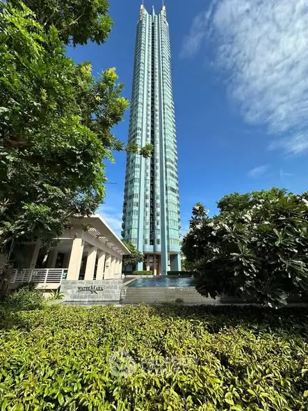 Stunning skyscraper with lush greenery and clear blue sky, showcasing modern architectural design.