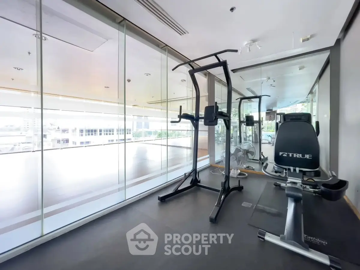 Modern gym with state-of-the-art equipment and glass walls offering a bright and open atmosphere.