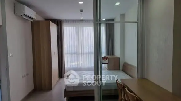 Modern bedroom with large window and wooden furniture in a stylish apartment.