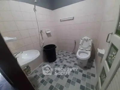 Spacious bathroom with modern fixtures and tiled walls, featuring a shower and toilet.