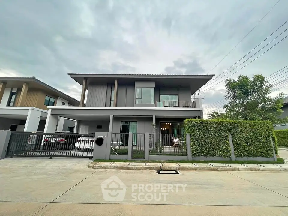 Modern two-story house with sleek design and lush greenery in a serene neighborhood.