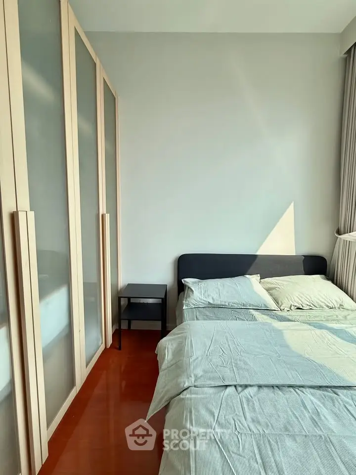 Modern bedroom with sleek wardrobe and cozy bed in natural light