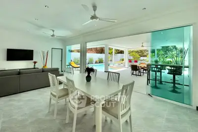 Spacious open-plan living and dining area with pool view, perfect for modern family living.
