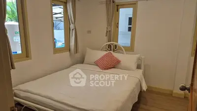 Cozy bedroom with natural light and simple decor, perfect for relaxation.