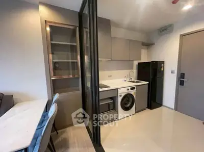 Modern kitchen with sleek appliances and stylish cabinetry in a compact layout.