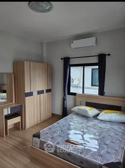Modern bedroom with wooden furniture and air conditioning in a cozy apartment.