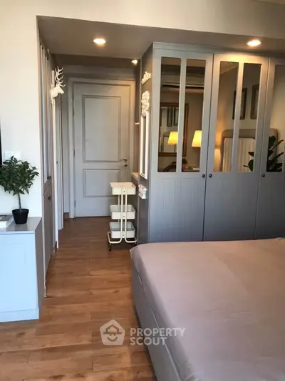 Modern bedroom with stylish wooden flooring and built-in wardrobe